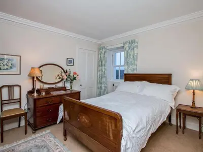 a bedroom with a bed and a dresser and a mirror at Country Home on Private Estate in Minishant