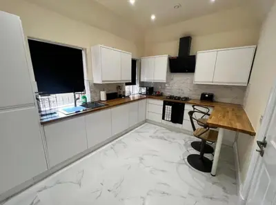 a kitchen with white cabinets and a marble floor at 3 Bed - Sleeps 7 - Free Parking - Central Location in Glasgow