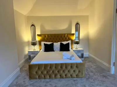 a large bedroom with a large bed with two night stands at 3 Bed - Sleeps 7 - Free Parking - Central Location in Glasgow