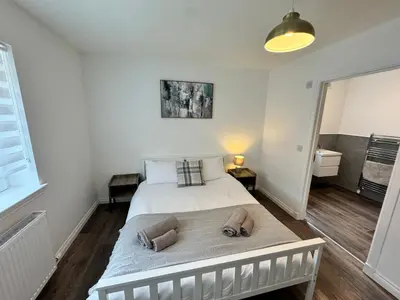 a bedroom with a bed with two towels on it at Inchcruin Apartment - Macaulay Letting in Bonhill
