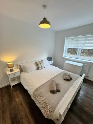 a bedroom with a bed with two slippers on it at Inchcruin Apartment - Macaulay Letting in Bonhill