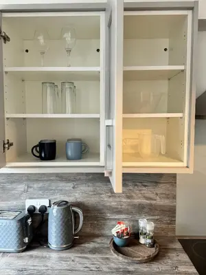 a kitchen cabinet filled with lots of dishes at Inchcruin Apartment - Macaulay Letting in Bonhill