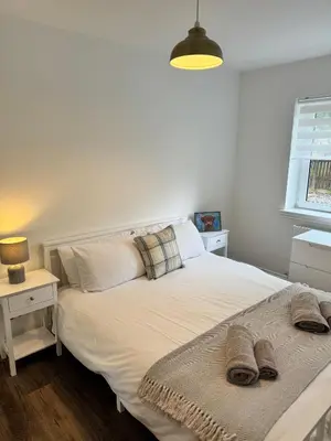 a bedroom with a bed with two pillows on it at Inchcruin Apartment - Macaulay Letting in Bonhill
