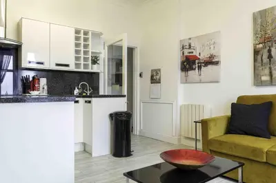 a kitchen and a living room with a couch and a table at Blackness Apartment in Linlithgow