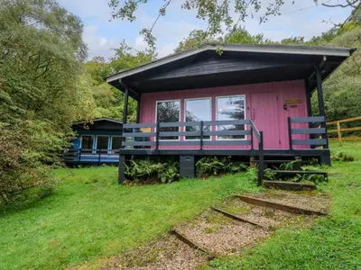 a small pink house with a black roof at Lodge 5 - 