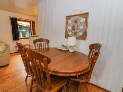 a wooden dining room table with chairs and a lamp at Lodge 5 - 
