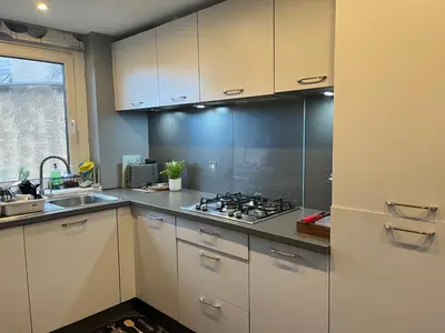 a kitchen with white cabinets and a stove at Room in a Home in Edinburgh