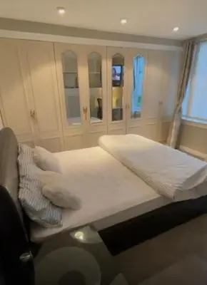 a bedroom with a large bed with white sheets and pillows at Room in a Home in Edinburgh