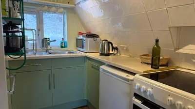 a small kitchen with a sink and a microwave at 1 Bedroom Cabin with Mountain & Loch Views - Quiet Location between Glencoe & Ben Nevis in Corran