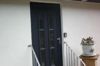 a door with a potted plant sitting on a porch at Highland Snug in Dunoon