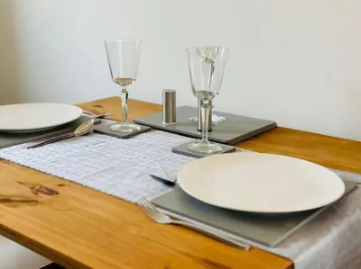 a table with plates and glasses on a wooden table at 2 Bed Entire Upper Cottage Flat in Central Glasgow in Glasgow