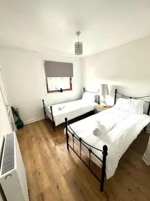 a bedroom with two beds and a television in it at 2 Bed Entire Upper Cottage Flat in Central Glasgow in Glasgow