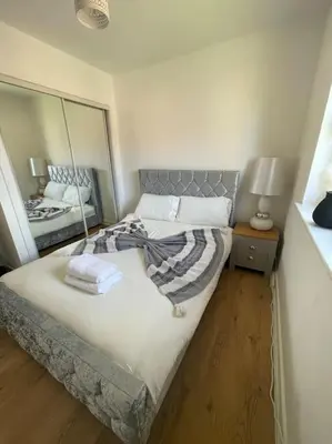 a bedroom with a large bed with a mirror at 2 Bed Entire Upper Cottage Flat in Central Glasgow in Glasgow