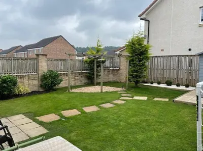 a backyard with a fence and a grass yard at Entire 4 bed perfect family home in Glasgow in Nitshill