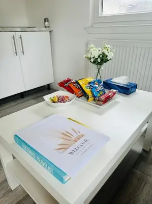 a white table with a book and snacks on it at Entire Private 1 Bedroom - Guest Suite in Glasgow in Glasgow