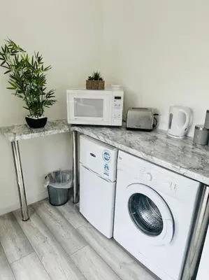 a kitchen with a washing machine and a microwave at Entire Private 1 Bedroom - Guest Suite in Glasgow in Glasgow
