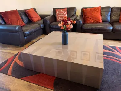 a coffee table with a vase of flowers on it at Holytown Homes in Holytown