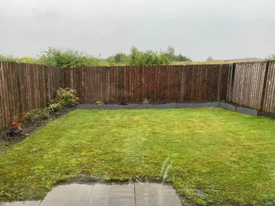 a backyard with a fence and a grass yard at Holytown Homes in Holytown