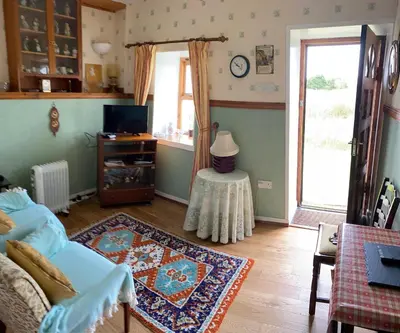 a living room with a couch and a table at Cottage-IsleofMull-StunningViews-WiFi-Parking in Bunessan
