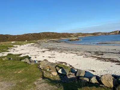 a sandy beach with rocks and the water at Cottage-IsleofMull-StunningViews-WiFi-Parking in Bunessan
