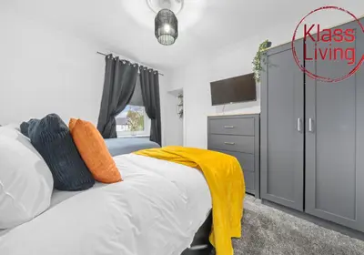 a bedroom with a bed with a yellow blanket on it at Fraser House by Klass Living Rutherglen in Glasgow