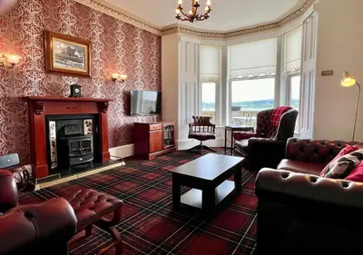 a living room filled with furniture and a fireplace at St Abbs in Innellan