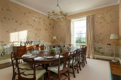 a dining room with a long table and chairs at Dabton House in Carronbridge