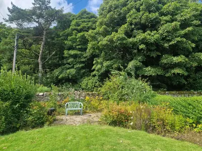 a blue bench sitting in the middle of a garden at Fairview Millport in Millport