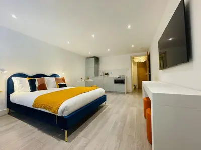 a bedroom with a king sized bed and a kitchen at Designer Studio in Edinburgh with Free Parking in Edinburgh