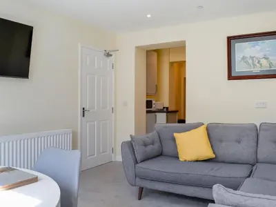 a living room with a couch and a yellow pillow at Oak -Apartment 4 in Aberfoyle