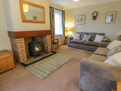 a living room with a fireplace and a couch at The Barn at Daldorch in Mauchline