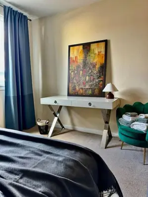 a bedroom with a table with a painting on the wall at Two bedroom maisonette in the heart of the West End in Glasgow