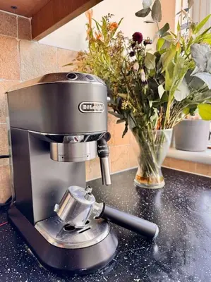 a coffee maker on a counter next to a vase of flowers at Two bedroom maisonette in the heart of the West End in Glasgow