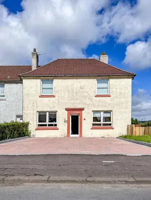 a large white brick house with a red door at Colourful life-house near Glasgow in Clydebank