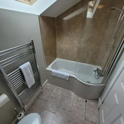 a bathroom with a bath tub and a toilet at Loch Lomond Finnich Cottages in Drymen