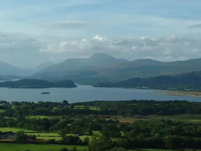 a view of a lake with mountains in the background at Ballat Smithy Cottage in Drymen