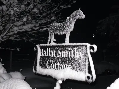 a sign with a cat standing on top of it at Ballat Smithy Cottage in Drymen