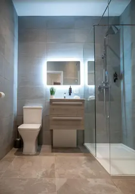 a bathroom with a toilet and a glass shower at The Hazlitt Apartments in Paisley