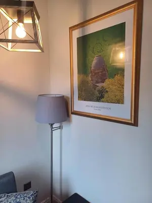 a picture hanging on a wall next to a lamp at The Hazlitt Apartments in Paisley