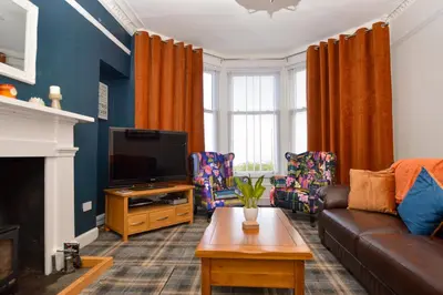 a living room with a couch and a tv at Crossaig Farm House in Crossaig