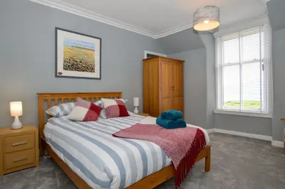 a bedroom with a bed with a teddy bear on it at Crossaig Farm House in Crossaig