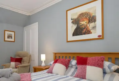 a bedroom with a bed with a picture on the wall at Crossaig Farm House in Crossaig