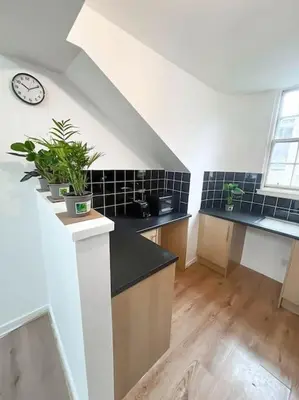 a kitchen with a sink and a clock on the wall at Edinburgh elms for 4 - New Town - City Center EB8 in Edinburgh