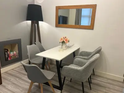 a dining room with a table and chairs and a mirror at 2B apartment near Glasgow SEC, OVO Hydro & city centre in Glasgow