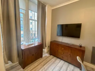 a living room with a flat screen tv and a window at 2B apartment near Glasgow SEC, OVO Hydro & city centre in Glasgow