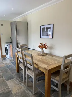 a dining room with a wooden table and chairs at 1 Inveravon Cottage in Falkirk