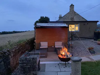 a building with a fire pit in front of it at 1 Inveravon Cottage in Falkirk