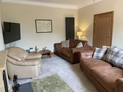 a living room with two couches and a tv at 1 Inveravon Cottage in Falkirk