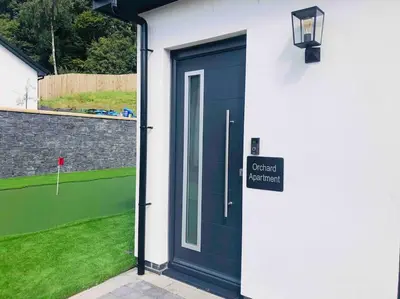 a blue door of a house with a golf course at The Orchard Apartment, Clyde Valley in Dalserf