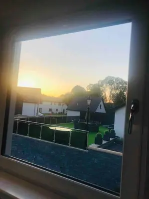 a window with a view of a yard with a house at The Orchard Apartment, Clyde Valley in Dalserf